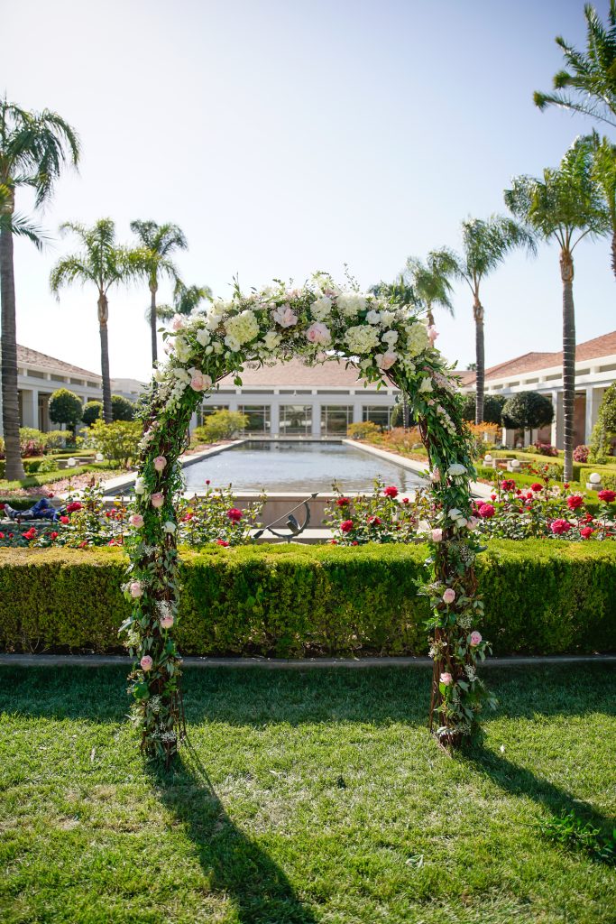 Outdoor wedding arch with vines and roses