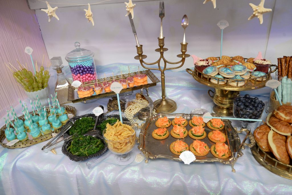 Mermaid launch party dessert and appetizer spread with vintage platters and decor