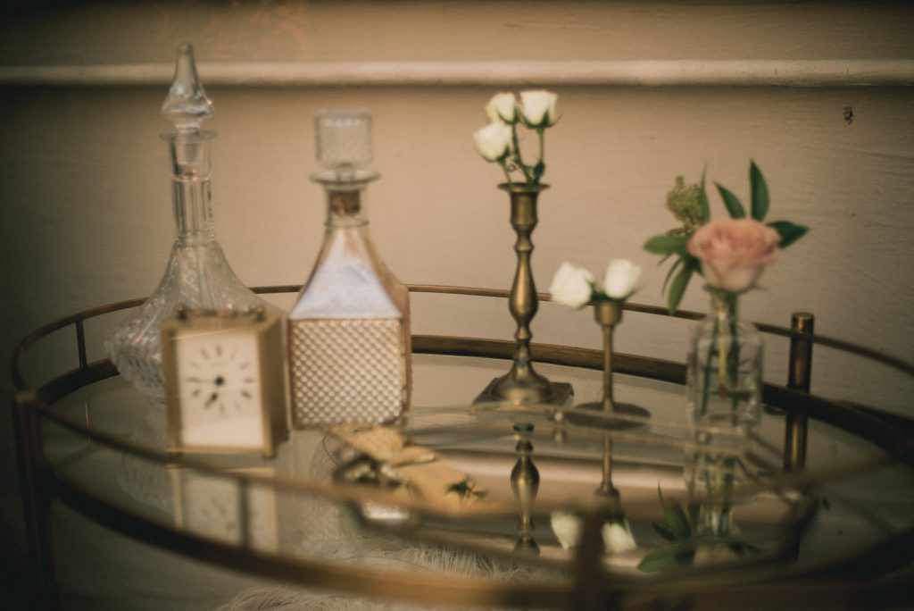 Vintage bar table with decanters, candle holders, and cigar bar. Vintage Wedding.