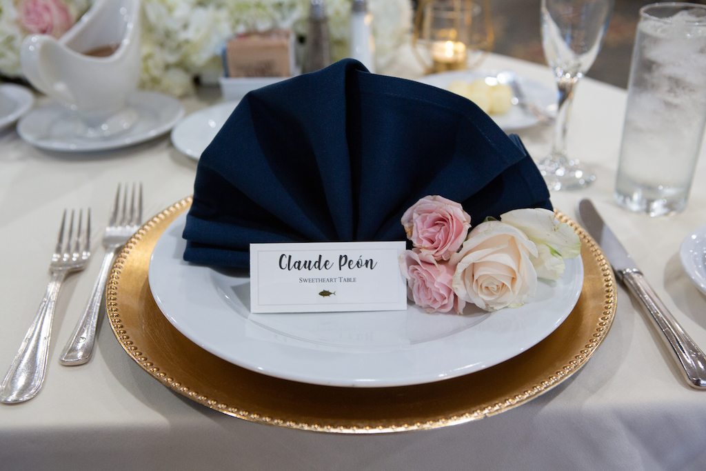 A classic sweetheart table set up for the groom, featuring gold beaded chargers and a navy blue napkin.

Edwin So Photography