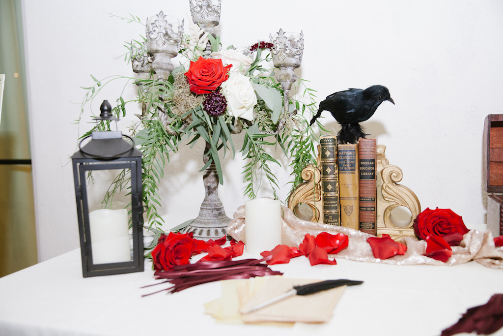 Details of the guestbook/welcome table, featuring vintage books and ravens.

Photo by GC Masterpiece