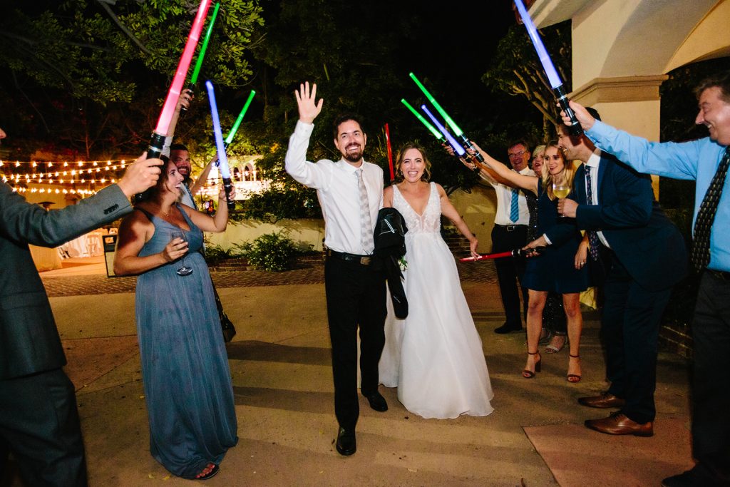 Guests send off the newlyweds with lightsabers drawn.